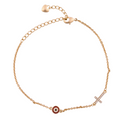 18k gold bracelet with evil eye charm and pavé cross on a white background