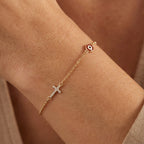 Evil eye and cross charm bracelet worn on the wrist