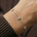 Floral charm bracelet worn on wrist