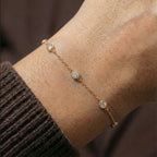 Delicate bezel-set stone bracelet worn on wrist