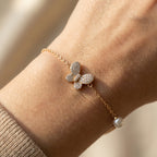 Butterfly charm bracelet with pearl accent worn on wrist