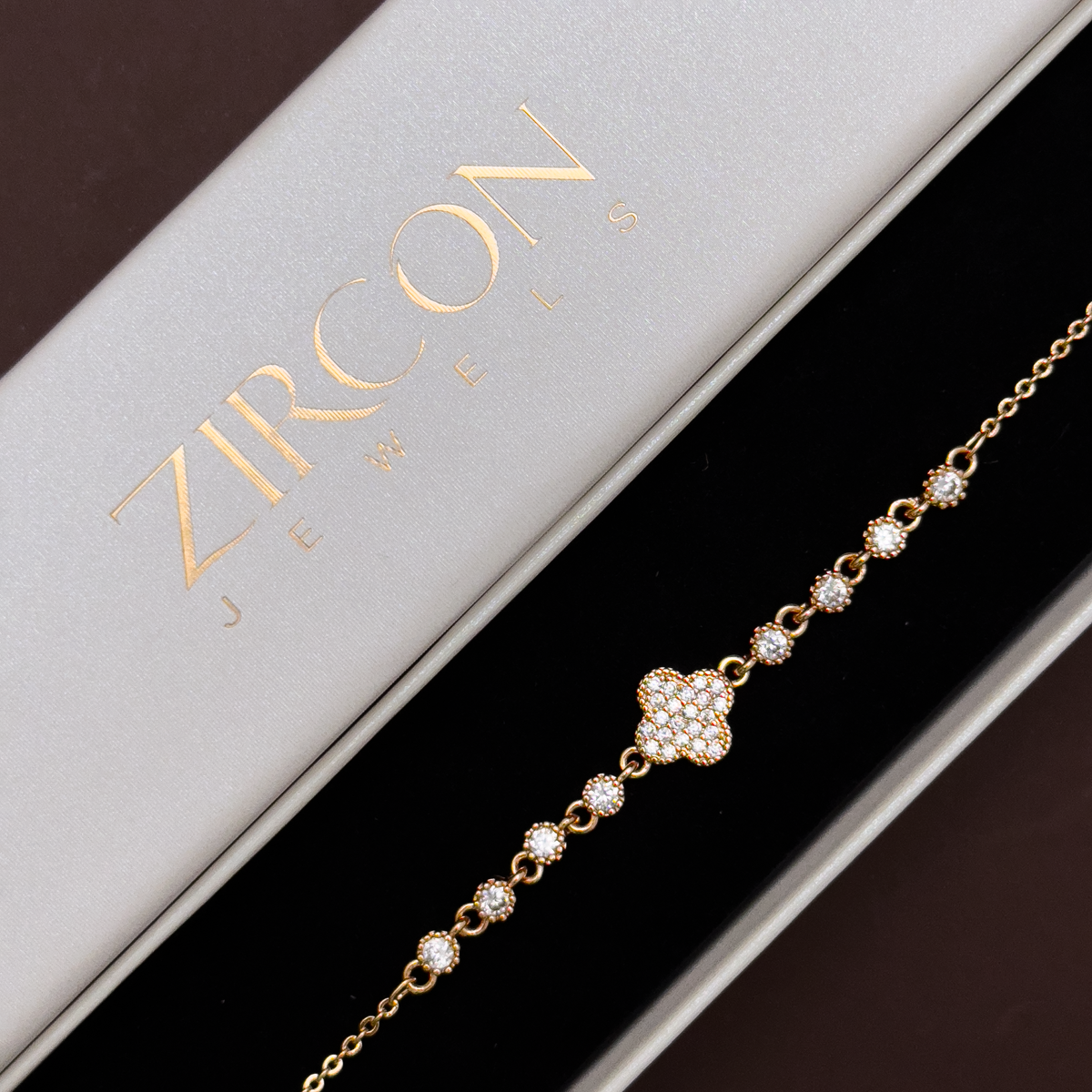 Gold clover charm bracelet displayed in Zircon Jewels gift box