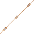 Close-up of micro-pavé cylindrical barrel charms on gold chain bracelet on a white background