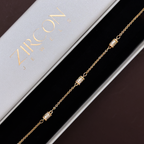 Close-up of micro-pavé cylindrical barrel charms on gold chain bracelet