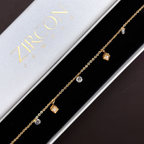 18k Gold bracelet with small charms on a Zircon branded box