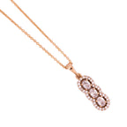 Close-up of the vertical three-stone pendant detail with a clear stone halo