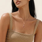 Infinity drop pendant necklace worn on the neck